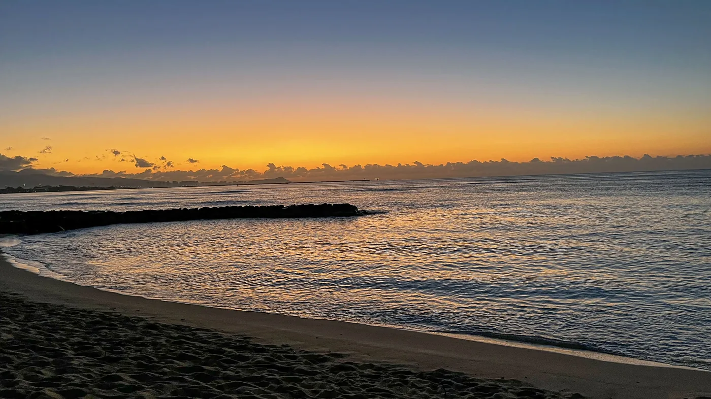 Sunset Beach with glowing shoreline and ocean horizon